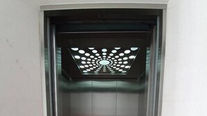 An elevator with a patterned ceiling and a brown floor. - Matini Amata (Phan Thong)