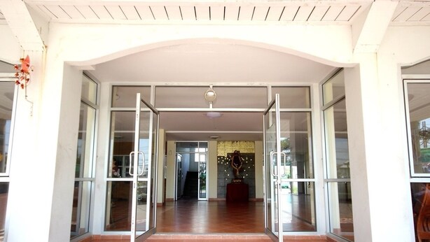 A hotel entrance with glass doors, a tiled floor, and a ceiling light. - Matini Amata (Phan Thong)
