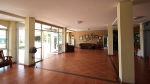 A spacious lobby with a large open area, a sofa, and a coffee machine. - Matini Amata (Phan Thong)
