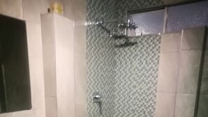A bathroom with a sink, mirror, shower, and bathtub. - Naisar Royal White Apartment (Germiston)