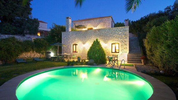 A stone building with a swimming pool, outdoor seating, and a well-lit patio area. - Stone villa with pool & fantastic sea views (with special autumn offers) (Rethymnon)