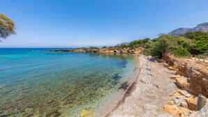 A coastal beach with clear water, rocky shore, and greenery. - Finca by the sea (Colonia de Sant Pere)