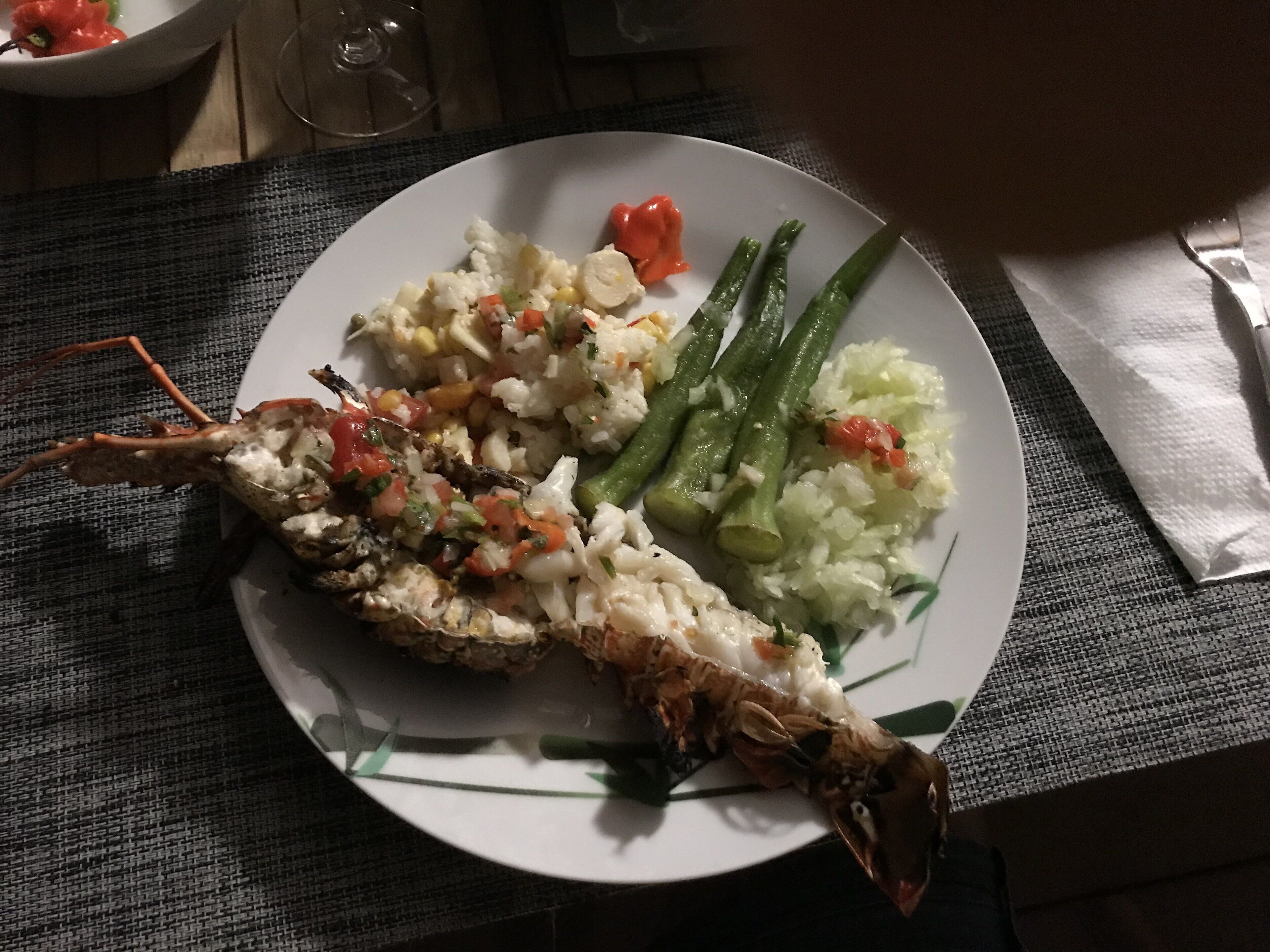 Een bord met gegrilde vis, rijst en sperziebonen.