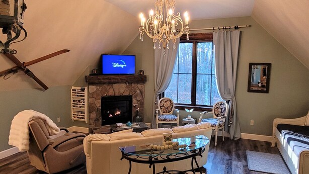 Una sala de estar acogedora con chimenea, televisor y candelabro.
