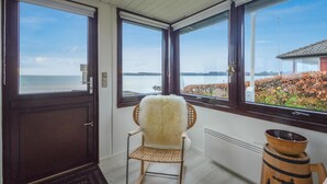 Une pièce avec vue sur un lac, une chaise et un tonneau en bois.