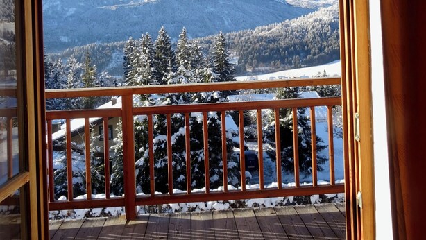 A wooden deck with a railing, a view of snow-covered mountains, and a clear sky. - Landhaus Mitsche, apartment panoramic view in a quiet, sunny position (Radnig)