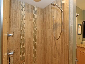 Een bad/douchecombinatie, een haardroger, handdoeken