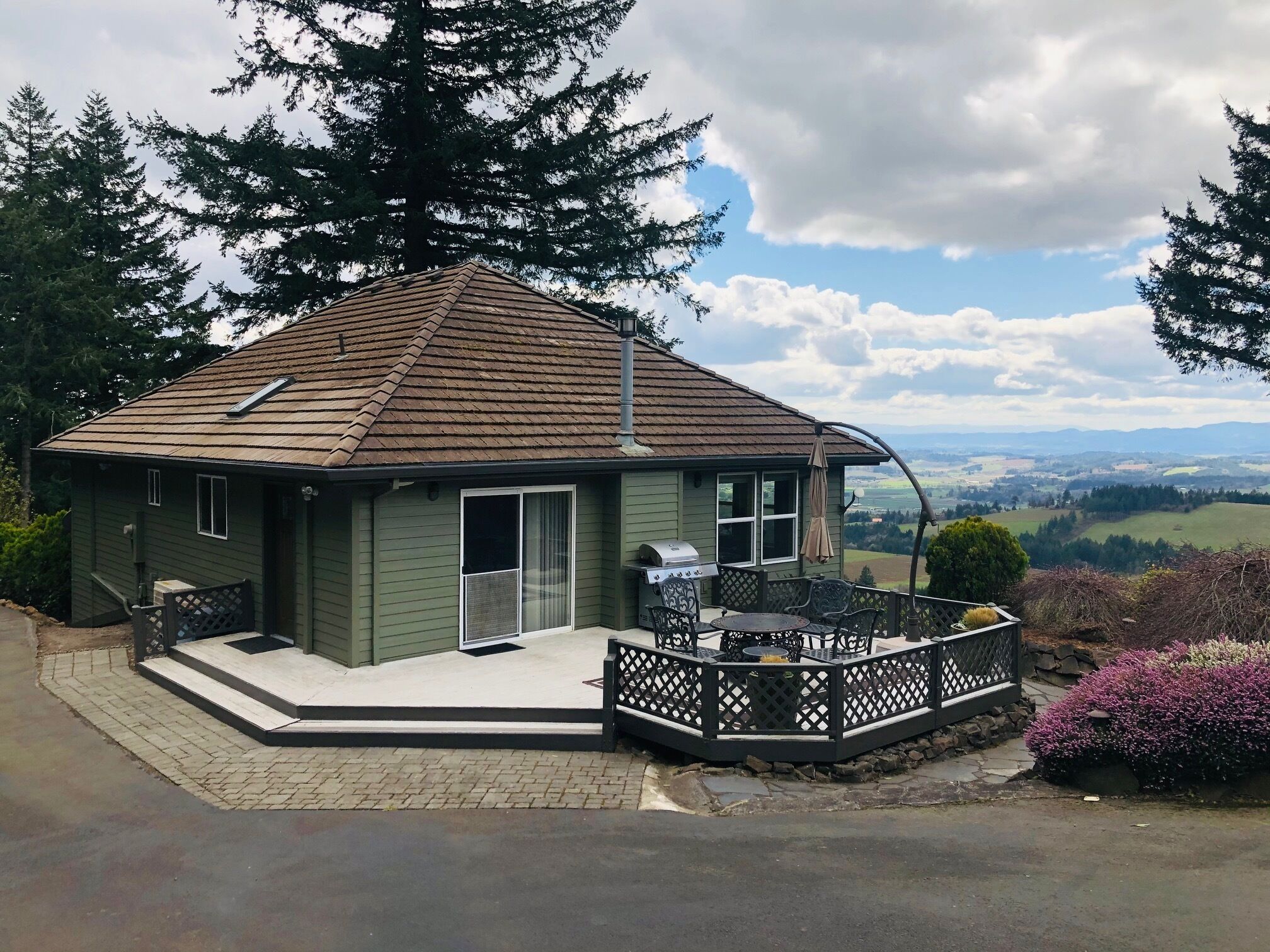 Une maison dotée d’un patio, d’un barbecue et offrant une vue panoramique sur le paysage.