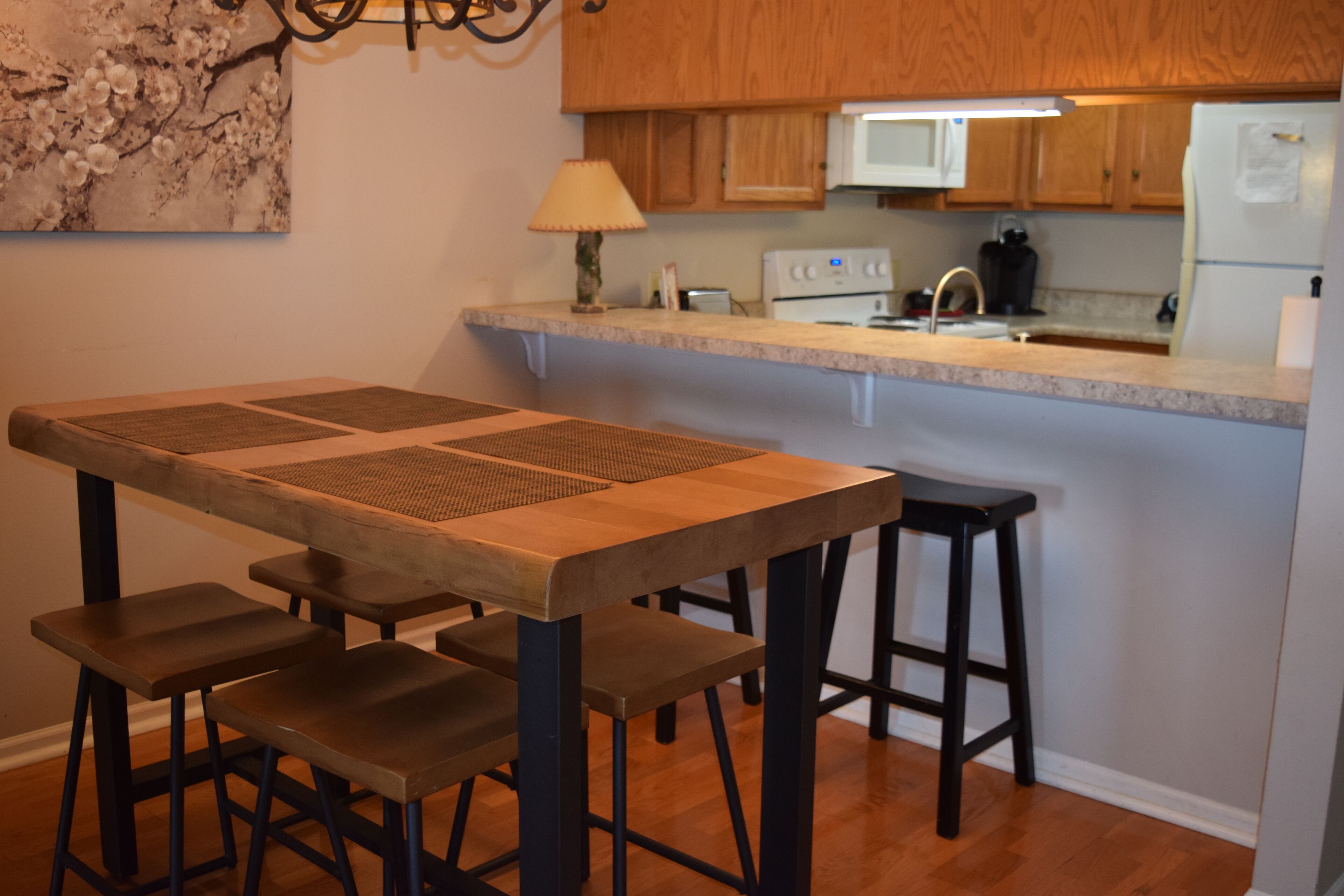 Una cocina con armarios de madera, una encimera, un microondas y un refrigerador.