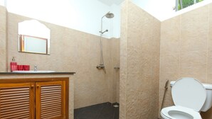 Un baño con ducha, inodoro y tocador de madera.