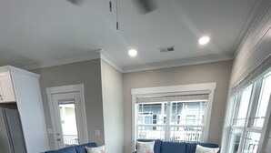 Una sala de estar con dos sofás azules, una mesa de centro blanca y un mueble blanco.