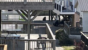 Una propiedad frente a la playa con una terraza de madera, un patio cubierto y vista al océano.