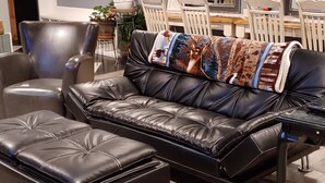 A black leather sofa with a matching ottoman, a wooden chair, and a small table with a remote control. - Pet Friendly, Scenic, Eureka, St Louis, Nurse, Insurance, Contractor spec. rates (High Ridge)