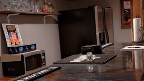 A kitchen with a microwave, a coffee maker, and a sink. There is a shelf with glassware and a picture frame. - Pet Friendly, Scenic, Eureka, St Louis, Nurse, Insurance, Contractor spec. rates (High Ridge)