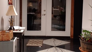 A modern interior with a glass door entrance, a lamp, a small table with a basket, and a potted plant. - Pet Friendly, Scenic, Eureka, St Louis, Nurse, Insurance, Contractor spec. rates (High Ridge)