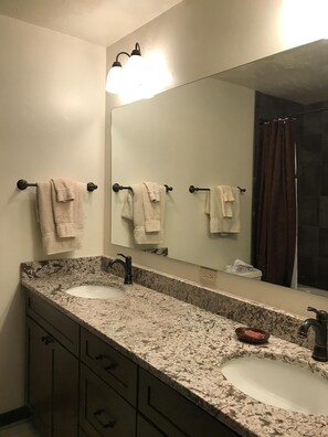 A bathroom with two sinks, a large mirror, and a shower curtain. - Remodeled ski in/ski out condo in Mt Crested Butte with incredible views! (Crested Butte)