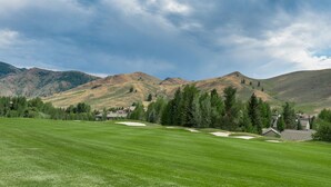 A golf course with a clear view of the surrounding mountains and a few buildings in the distance. - Fairway Nine Town Home Retreat Sun Valley (Sun Valley)
