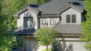A two-story house with a garage, a driveway, and a mountain backdrop. - Fairway Nine Town Home Retreat Sun Valley (Sun Valley)