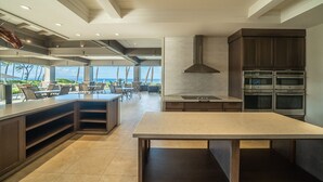 A modern kitchen with a large island, built-in oven, and a view of the ocean. - Largest Two Bedroom/ Two Bath in the Village, Sleeps Eight & Close to the Beach (Wailea)