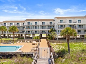 A hotel with multiple floors, outdoor pool, and palm trees.