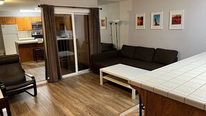 A compact living space with a kitchenette, a sofa, a coffee table, and a sliding glass door leading to a balcony. - Las Palmas Spectacular View-Elevator, Washer-Dryer, No Resort Fees - Great RATE! (St George)