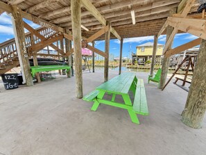 A wooden deck with picnic tables and a staircase.