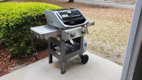 Un barbecue portable doté d’un écran numérique, de deux boutons de réglage et d’un compartiment de rangement.