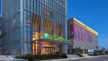 Un moderno edificio de hotel con una entrada destacada y señalización de Holiday Inn Express.