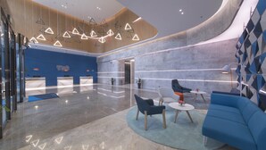 A modern lobby with a reception desk, seating area, and a curved wall with geometric patterns. - Holiday Inn Express Liyang Huafu by IHG (Changzhou)
