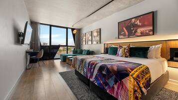 Habitación de hotel moderna con una cama grande, un escritorio y vistas a la ciudad.