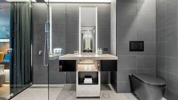 A modern bathroom with a glass shower enclosure, a large mirror, and a sleek toilet.