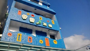 Un edificio con fachada azul y formas geométricas de colores.