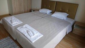 A neatly made bed with a headboard, two pillows, and two folded towels on the bed. - Falkenstein Aparts (Falkenstein/Vogtl.)