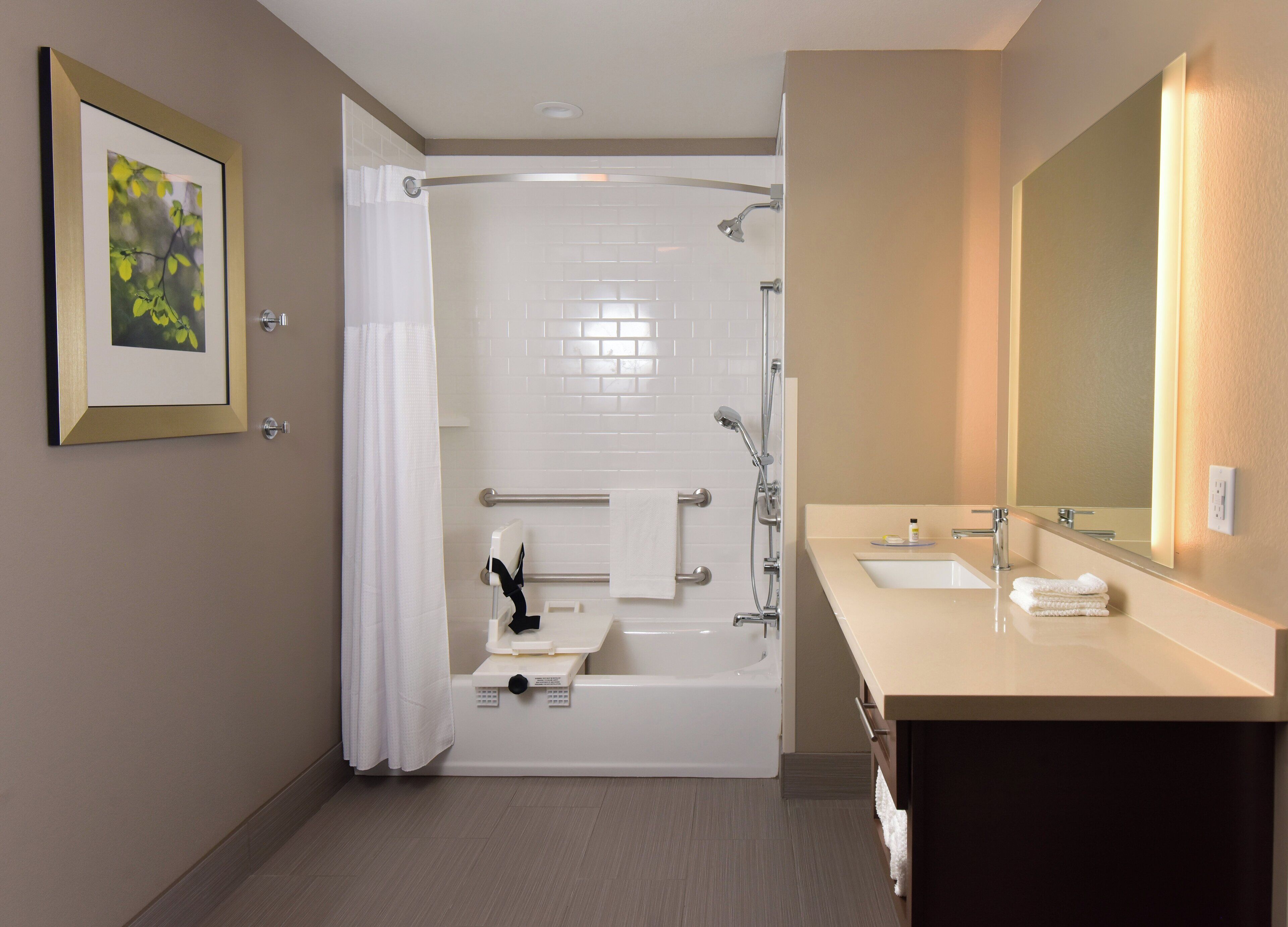 A modern bathroom with a bathtub, shower, and a vanity with a mirror.
