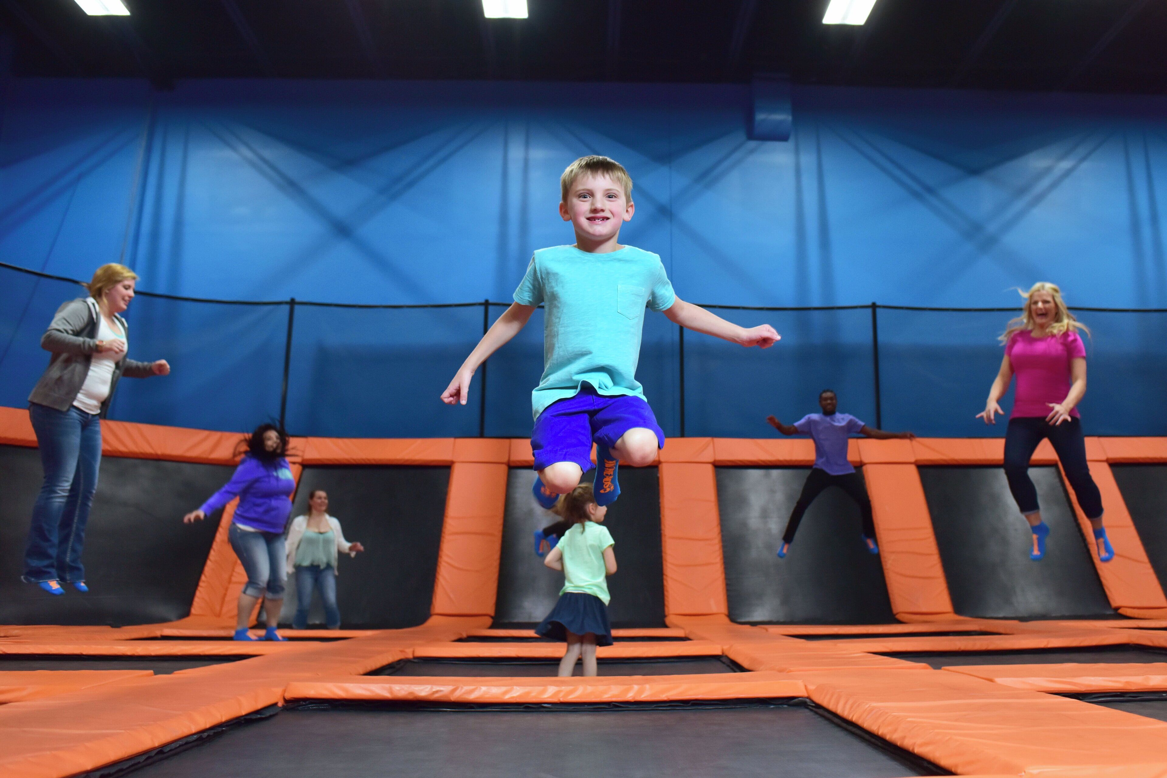 Un parc de trampolines avec de nombreux trampolines et des gens qui sautent.