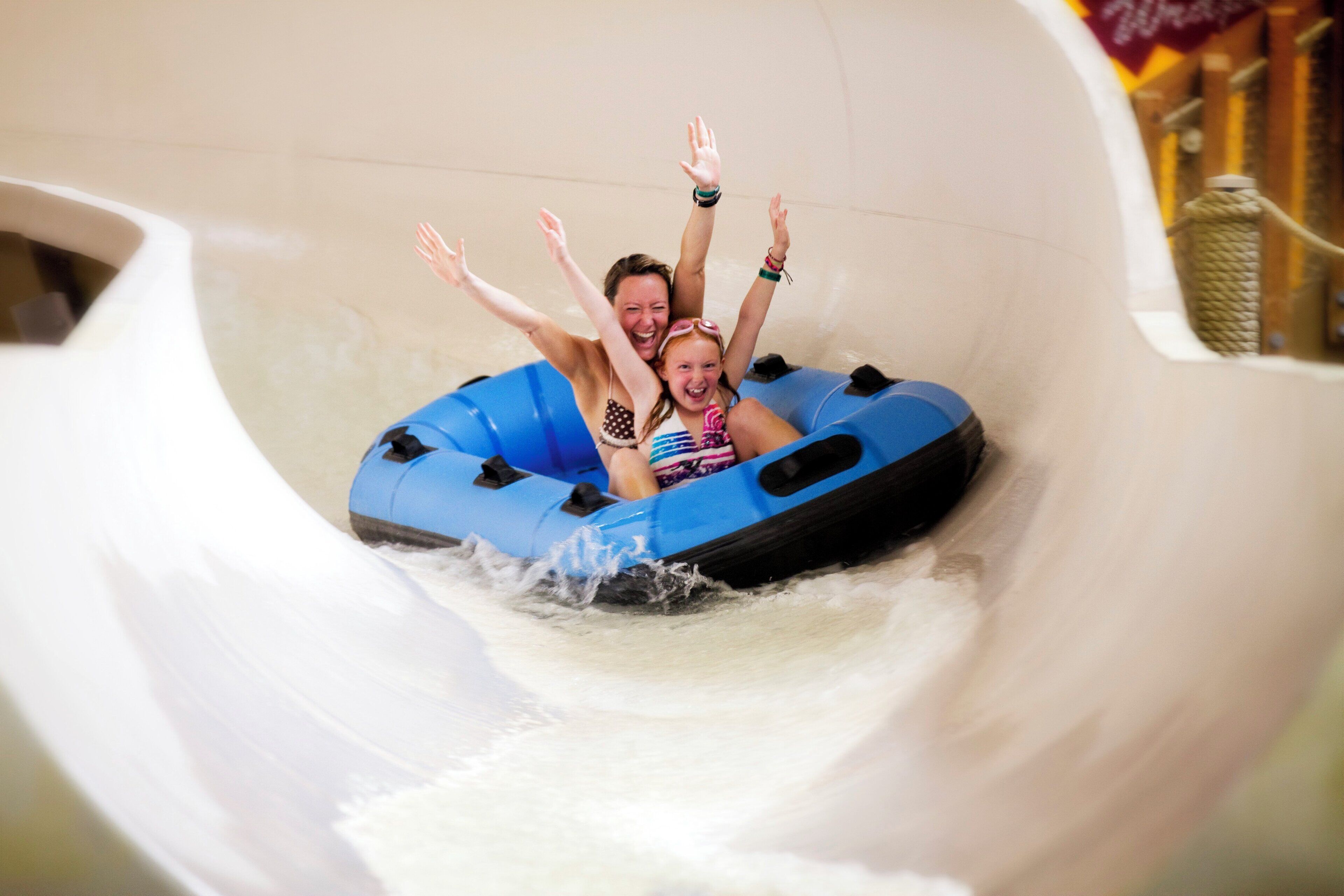 A water slide with two people in a blue tube.