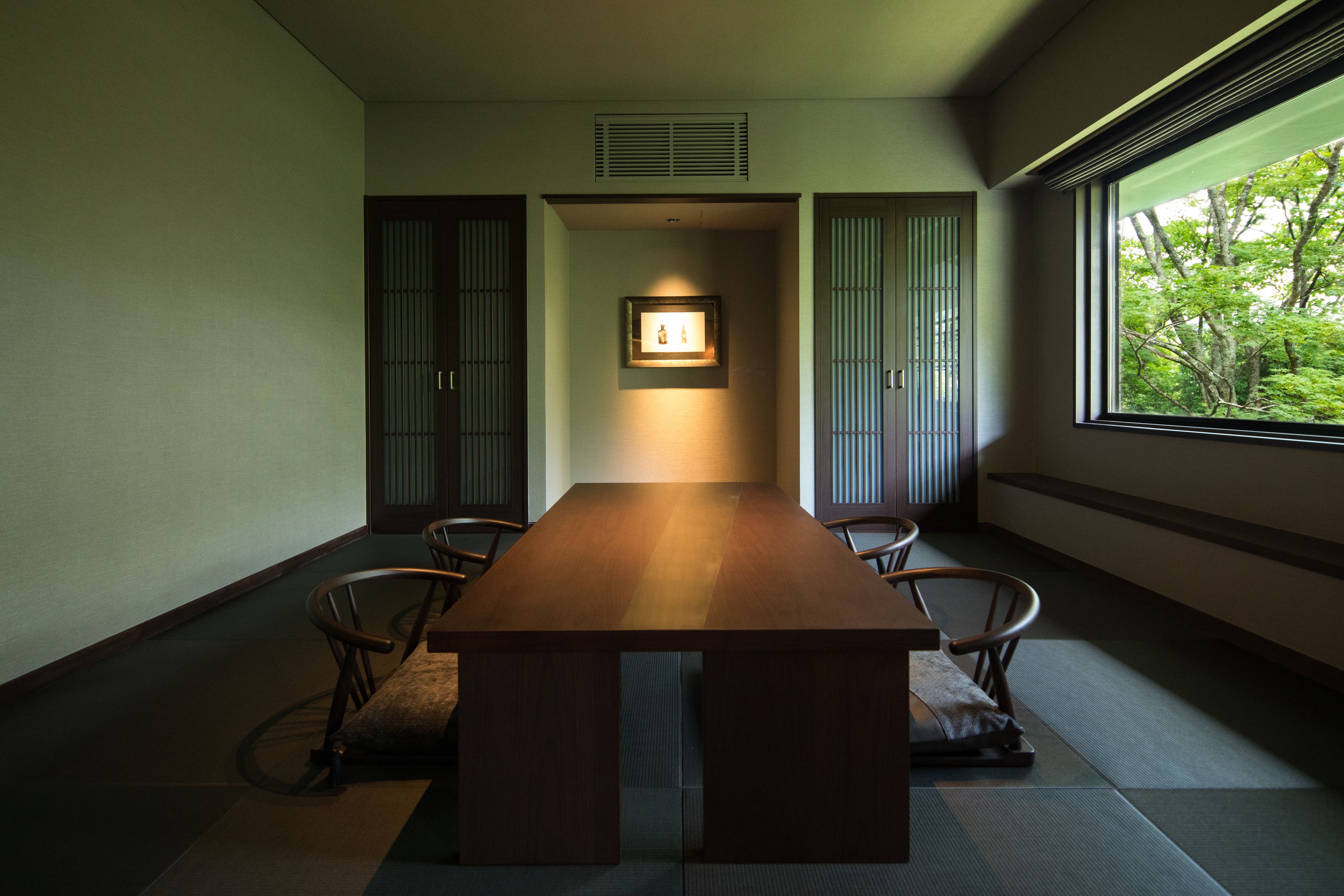A traditional Japanese-style room with tatami flooring, a low wooden table, and sliding doors.