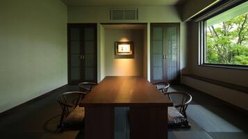 A traditional Japanese-style room with tatami flooring, a low wooden table, and sliding doors.