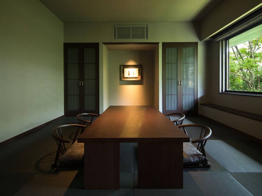 A traditional Japanese-style room with tatami flooring, a low wooden table, and sliding doors.
