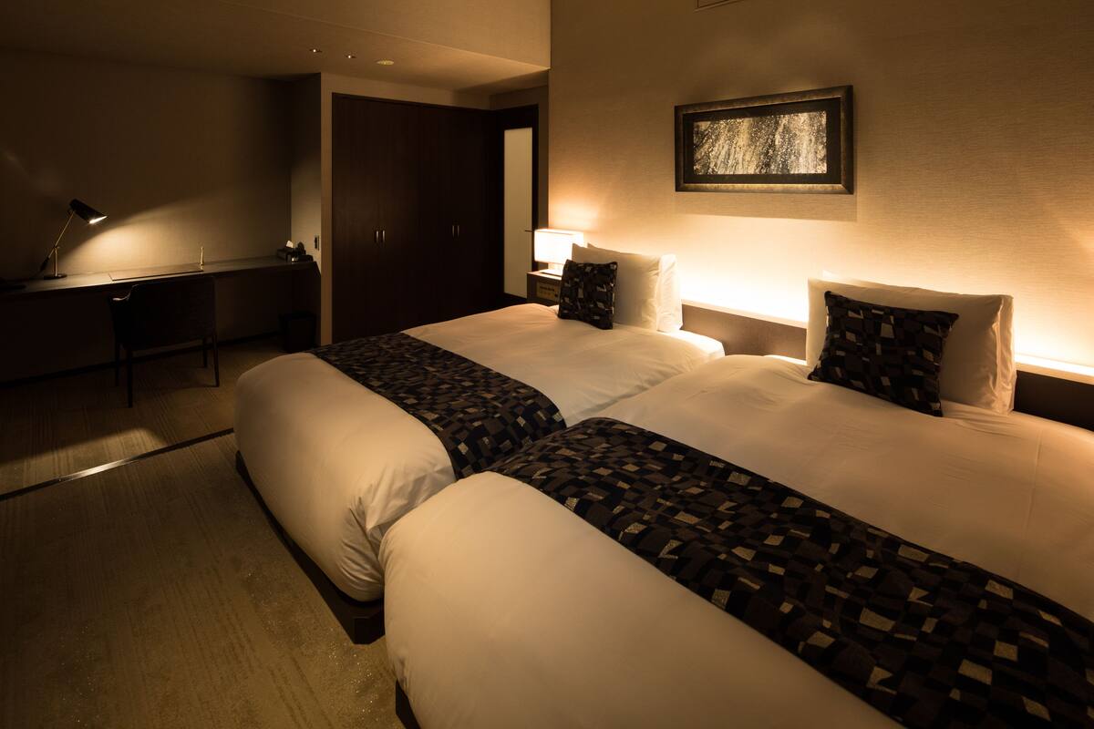 Una habitación de hotel con dos camas, un escritorio y una silla.