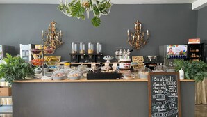 A breakfast bar with a chalkboard menu listing items like brioche, pancakes, and yogurt. - Hotel Major (Cervia)