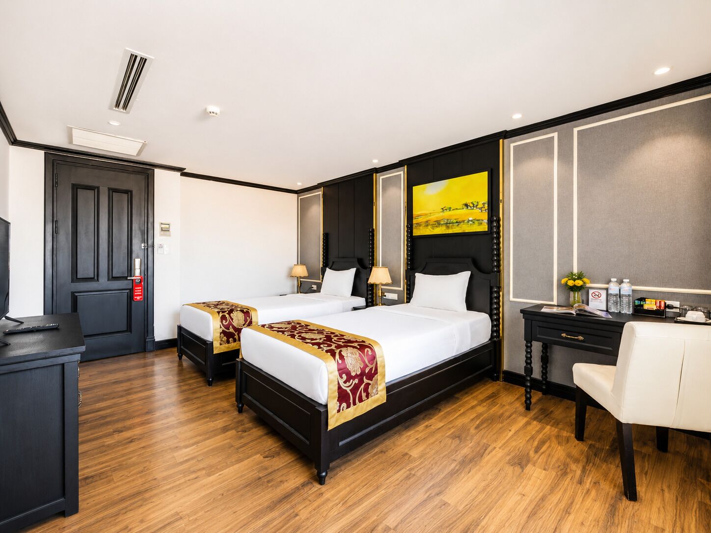 Une chambre d’hôtel avec deux lits, un bureau et une chaise.