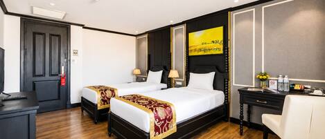 Une chambre d’hôtel avec deux lits, un bureau et une chaise.