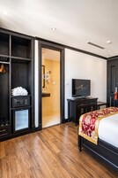 A hotel room with a bed, a television, a wardrobe, and a walk-in closet.