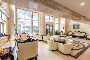 A spacious lobby with high ceilings, large windows, and classic furniture. - Aaron Vientiane Hotel (Vientiane)