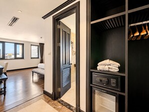 Habitación de hotel con un ventanal grande, una cama, armario con espejo y calefacción incorporada.