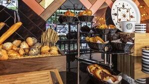 Una vitrina de panadería con diversos productos horneados, como pan, pasteles y galletas, organizados en estantes y cestas.