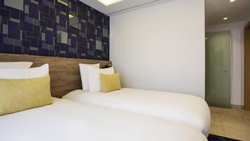 Una habitación de hotel con dos camas, un cabecero de madera y una pared con un diseño geométrico.