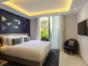 A modern hotel room with a large bed, a seating area, and a view of greenery outside. - Aparthotel Adagio Premium Casablanca City Center (Casablanca)