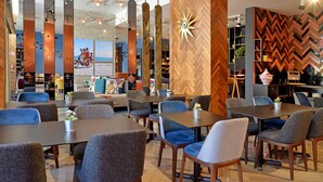 A modern restaurant with a variety of seating options, including tables and chairs, and a decorative wall with a geometric pattern. - Aparthotel Adagio Premium Casablanca City Center (Casablanca)